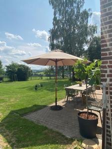 une terrasse avec un parasol, une table et des chaises dans l'établissement Ô Macra House - Aubel, Pays de Herve, à Aubel