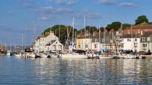 un grupo de barcos atracados en un puerto con casas en Bosun`s Cottage Luxury stay in the heart of town, en Weymouth