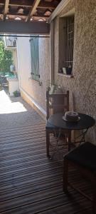 eine Terrasse mit einem Tisch und einem Stuhl auf einer Terrasse in der Unterkunft Chez Christian et Valérie in Rocbaron