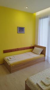 two beds in a room with a yellow wall at Family Hotel Kentavar 2 in Byala