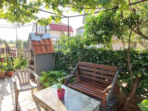 un banco de madera, una mesa y una silla en Luxury Apartments Bitola en Bitola