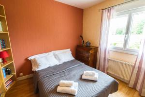 een slaapkamer met een bed met twee handdoeken erop bij Clos Fleuri : Amboise Home with Amazing Gardens in Amboise