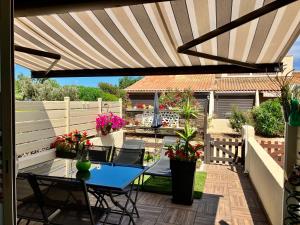 a patio with a table and chairs under a pergola at Naturiste Heliovillage Villa de Standing in Cap d'Agde