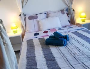 Un dormitorio con una cama con toallas azules. en Cosy & Calme en Le Tampon