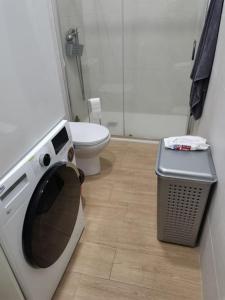 a bathroom with a washing machine and a toilet at RockSide Residences Suites La Línea A8 in La Línea de la Concepción
