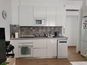 a white kitchen with a sink and a microwave at RockSide Residences Suites La Línea A8 in La Línea de la Concepción