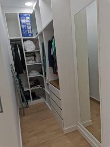 a walk in closet with white cabinets and a mirror at RockSide Residences Suites La Línea A8 in La Línea de la Concepción