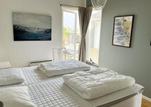 2 Einzelbetten in einem Schlafzimmer mit Fenster in der Unterkunft Unique holiday accommodation on Langholmen in Gothenburgs western archipelago in Torslanda