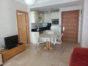 sala de estar con mesa y cocina en Gold city Alanya - 5 star two bedroom hotel apartment with full Sea view, en Alanya
