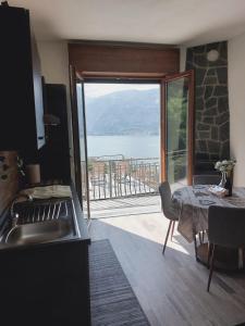 a kitchen with a table and a view of the ocean at Dudi Jolie Maison - Jacuzzi in Lezzeno