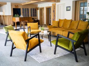 uma sala de estar com um sofá, cadeiras e uma mesa em Hotel Sternen Unterwasser em Unterwasser