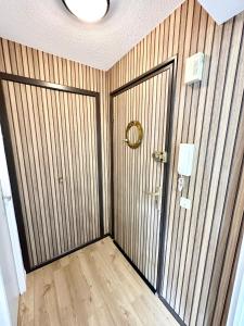 Habitación con paredes revestidas de madera y puerta. en Studio archi cosy – Refait à neuf – 5min des plages, en Quiberon