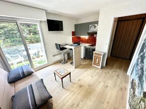 sala de estar con sofá y cocina con escritorio en Studio archi cosy – Refait à neuf – 5min des plages, en Quiberon