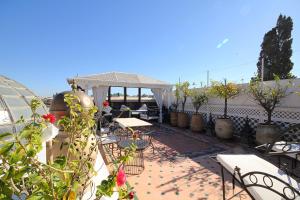 eine Terrasse mit Tischen, Stühlen und einem Pavillon in der Unterkunft Riad Esmeralda in Marrakesch