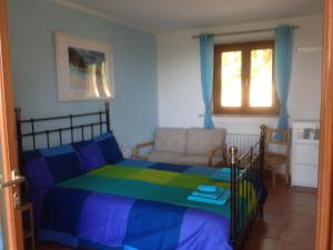 ein Schlafzimmer mit einem Bett, einem Sofa und einem Fenster in der Unterkunft Il Parco in Ancona