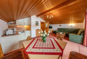 a living room with a table and a kitchen at Walchensee - Alpenblick Tilly in Krün