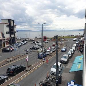 a busy street with cars parked in a parking lot at Cosy beachfront apartment in Salthill Galway city in Galway