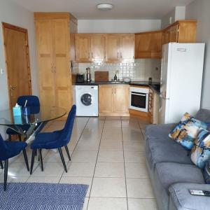 a kitchen with a couch and a table and a refrigerator at Cosy beachfront apartment in Salthill Galway city in Galway