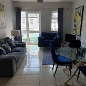 a living room with a couch and a glass table at Cosy beachfront apartment in Salthill Galway city in Galway