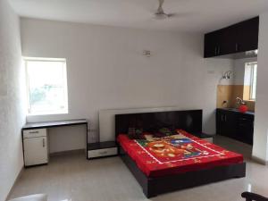Un dormitorio con una cama con una manta roja. en Ac Beautiful Luxury stay in Omaxe Vrindavan Jai bankebihariji by Shishamare en Vrindāvan