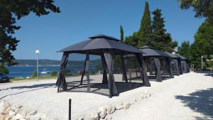 a row of umbrellas in the sand near the water at 5 meters FROM THE SEA with private beach - 70m2 Colibri Sunset Apartments in Sveti Petar