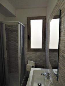 a bathroom with a sink and a shower and a mirror at Casa Foddis - Bed and View in Baunei