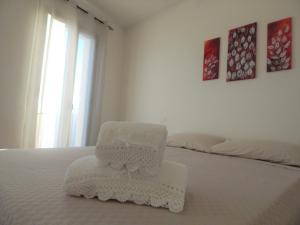 Una cama blanca con una silla blanca encima. en Casa Foddis - Bed and View en Baunei