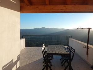 einen Tisch und Stühle auf einem Balkon mit Aussicht in der Unterkunft Casa Foddis - Bed and View in Baunei