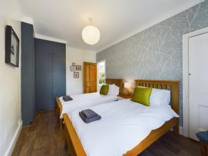 2 camas individuales en un dormitorio con almohadas verdes en Acacia House, en Wolsingham
