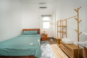 a bedroom with a bed and a dresser and a window at Thanh Homestay Đà Nẵng gần sân bay và trung tâm thành phố in Da Nang