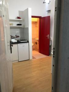 um quarto com uma cozinha e uma porta vermelha em Cozy Max Studio em Jagodina