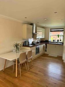 a kitchen with a table and chairs in a room at NEW! 3 bedroom. On-drive parking. Close to the A1 in Long Bennington