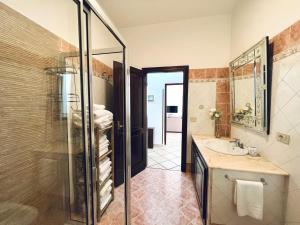 Un baño con ducha de cristal y lavabo. en Villa Genova, en Carini 52 fotos más