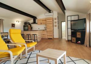een woonkamer met gele stoelen en een tafel bij BOHO location 2 in Bonnieux