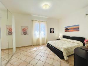Un dormitorio con una cama y una pared de cristal. en Villa Genova, en Carini