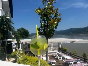 una copa con un limón en un vaso en un balcón en Riviera 990 - Resort & Restaurant, en Eşelniţa