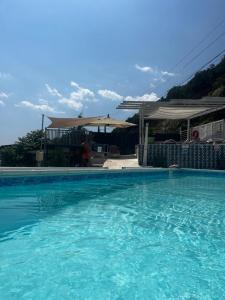 ein großer blauer Pool mit einem Haus im Hintergrund in der Unterkunft Riviera 990 - Resort & Restaurant in Eşelniţa