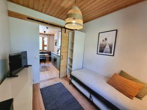 uma sala de estar com um sofá e uma televisão num quarto em Ylläksen Metsäpirtti - Ulkoilijan koti em Äkäslompolo
