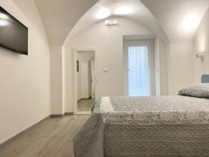 ein weißes Schlafzimmer mit einem Bett und einem Fenster in der Unterkunft Casa Nonna Lucia - Puglia Mia Apartments in Monopoli