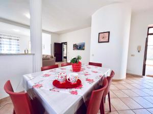 una mesa de comedor con sillas rojas y dos tazas. en Villa Genova, en Carini