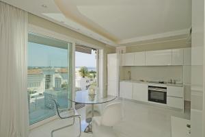 a kitchen with a glass table and a large window at La Castellana C89 by Wonderful Italy in Sirmione