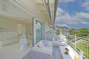 a balcony with white furniture and a view at La Castellana C89 by Wonderful Italy in Sirmione