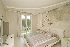ein weißes Schlafzimmer mit einem Bett und einem Fenster in der Unterkunft La Castellana C89 by Wonderful Italy in Sirmione