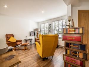 a living room with a yellow chair and a table at Pass the Keys Stylish family home central Topsham with parking in Exeter