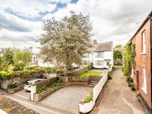 una vista exterior de una casa con un árbol y un camino de entrada en Pass the Keys Stylish family home central Topsham with parking en Exeter