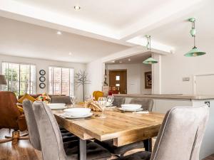 cocina y comedor con mesa de madera y sillas en Pass the Keys Stylish family home central Topsham with parking en Exeter