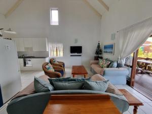 uma sala de estar com um sofá e uma cozinha em The Dune Hideaway em Port Alfred