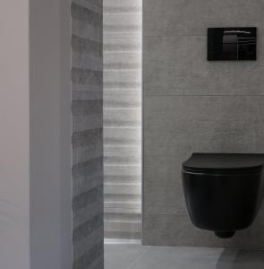 a bathroom with a black toilet and a wall at Golden Island Resorts in Athens