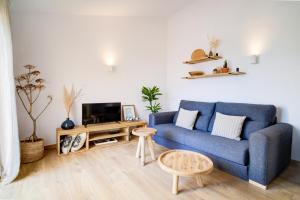 un salon avec un canapé bleu et une table dans l'établissement Surmar - Apartamento con piscina en Cap d'Artrutx, à Cala'n Bosch