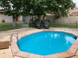 - une grande piscine bleue avec 2 chaises dans la cour dans l'établissement Villa les Platanes Aix en Provence, à Aix-en-Provence